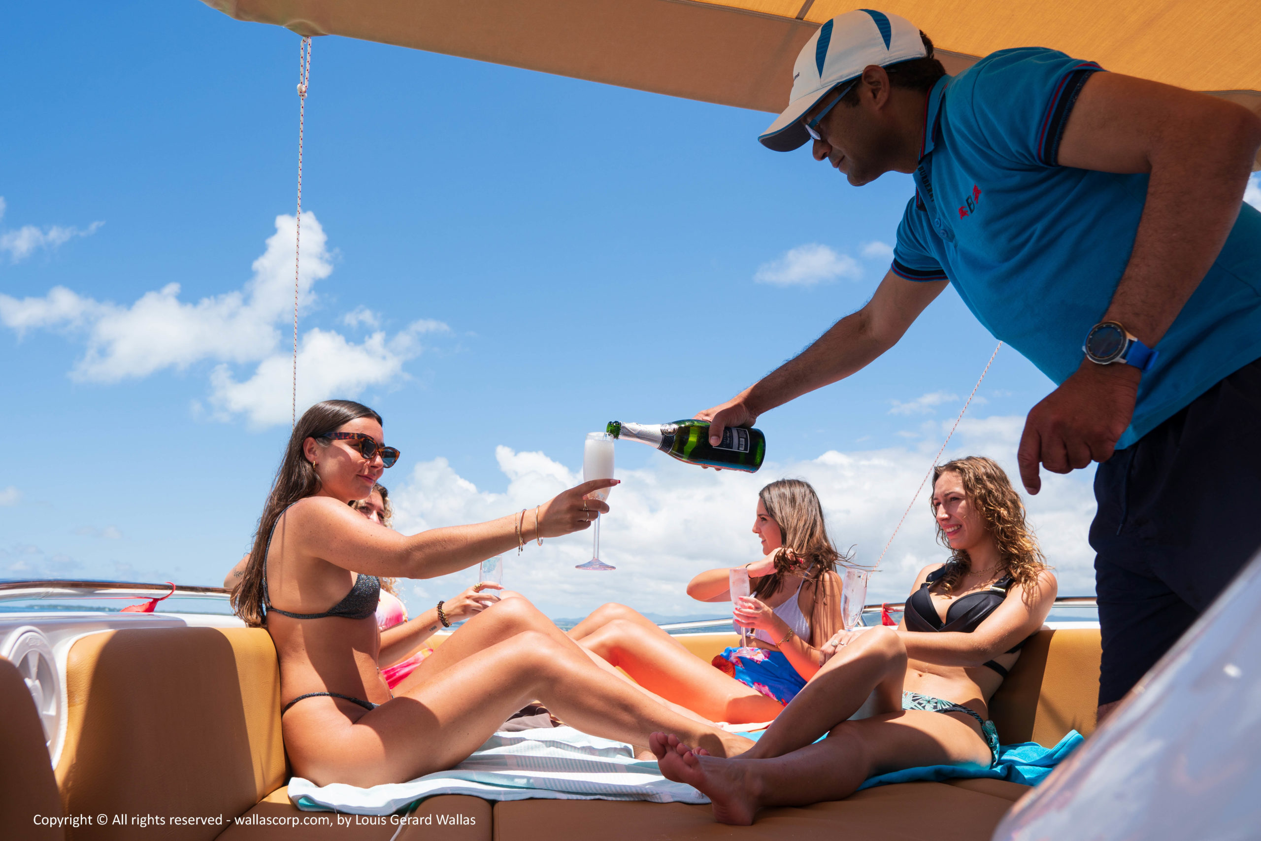 Crew serving drinks to guests relaxing on a boat charter in Mauritius